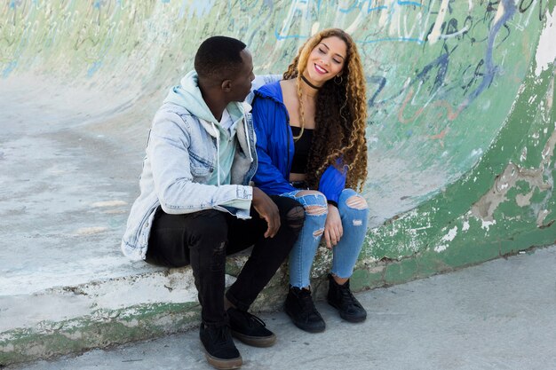 Pareja afro americana sentada en half pipe