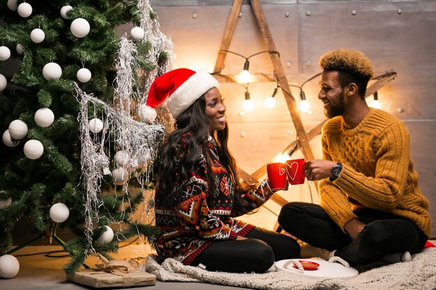 Pareja afroamericana, bebida, café, por el árbol de navidad