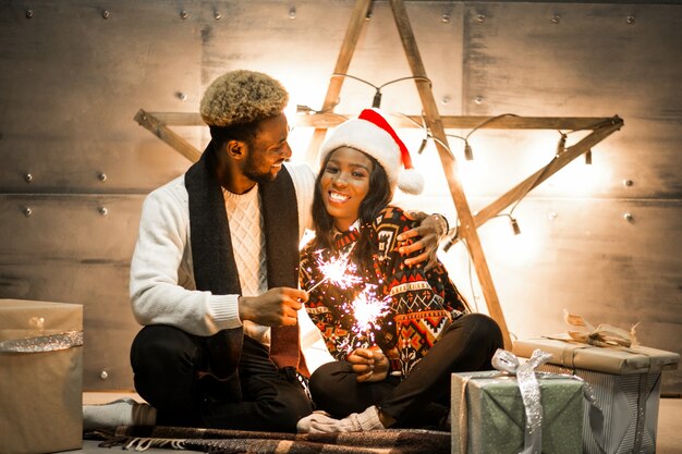 Pareja afroamericana, sentado, con, luces de bengala