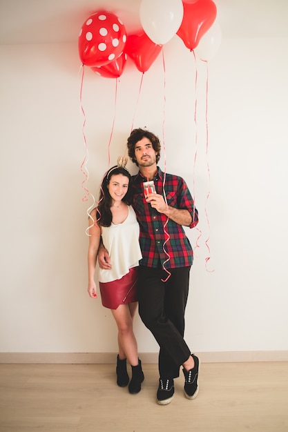 Foto gratuita pareja agarrada de la cintura con globos alrededor