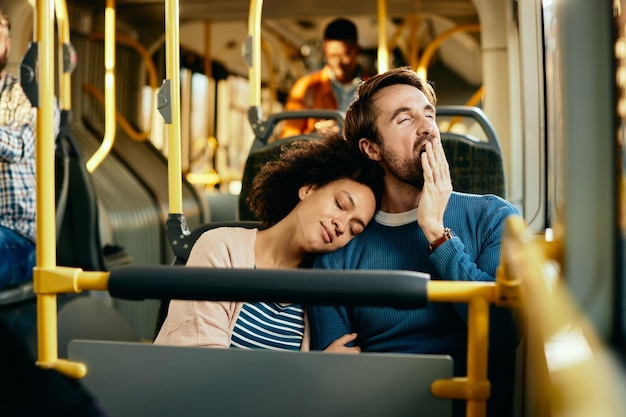 Pareja agotada viajando juntos en autobús