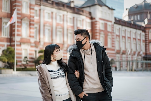 Pareja al aire libre junto con máscaras médicas