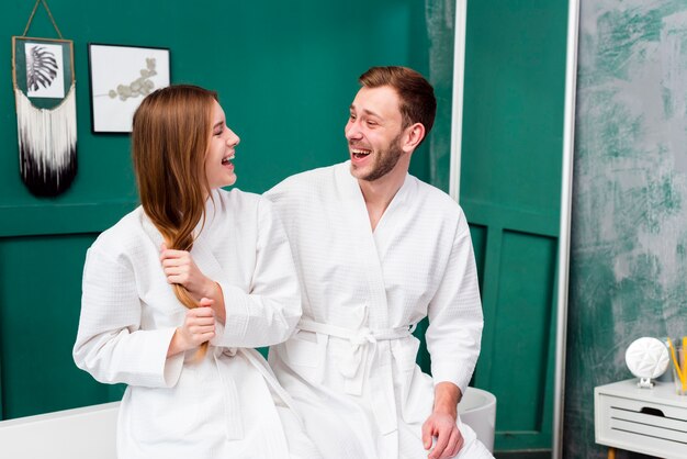 Pareja de albornoces mirándose y sonriendo