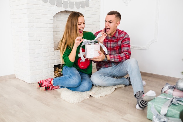 Pareja alegre abriendo regalo