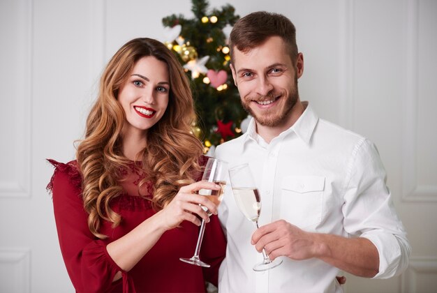 Pareja alegre con champagne brindando