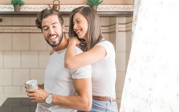 Foto gratuita pareja alegre en la cocina por la mañana