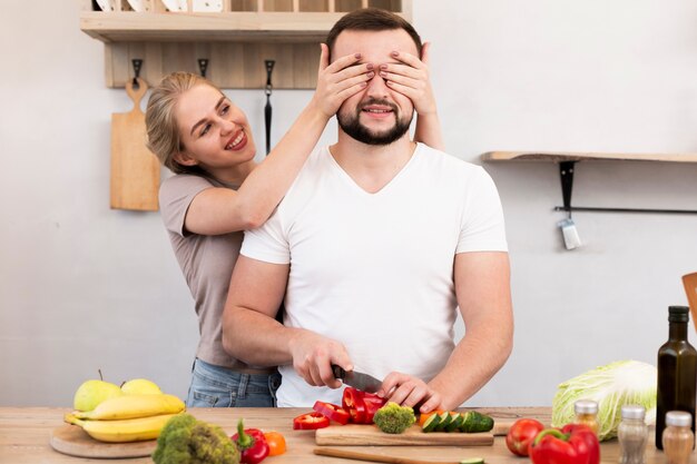 Pareja alegre cocinando en la cocina