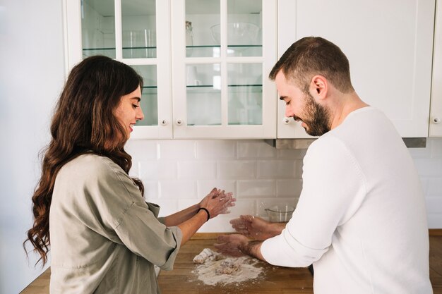 Pareja alegre cocinar amasar