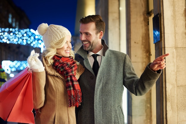 Pareja alegre de compras juntos al aire libre