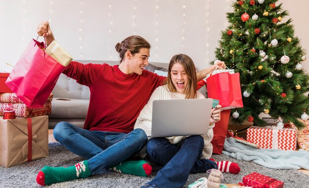 Pareja alegre con compras navideñas