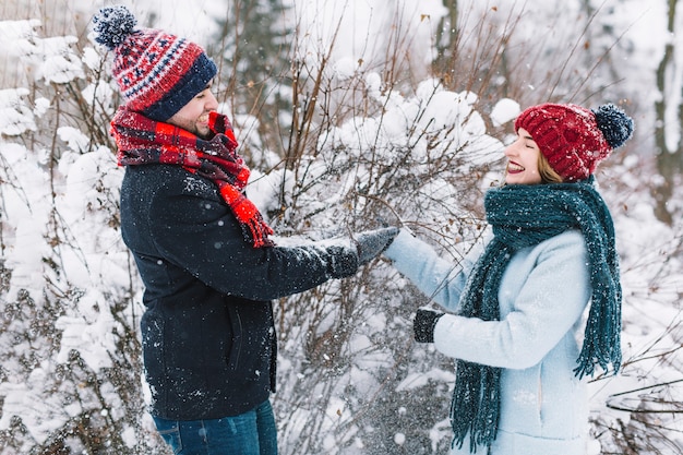 Pareja alegre disfrutando de la actividad de invierno