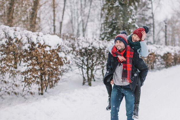 Pareja alegre disfrutando de invierno en el amor