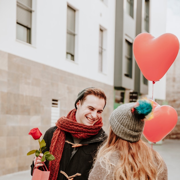 Pareja alegre con globos y regalos