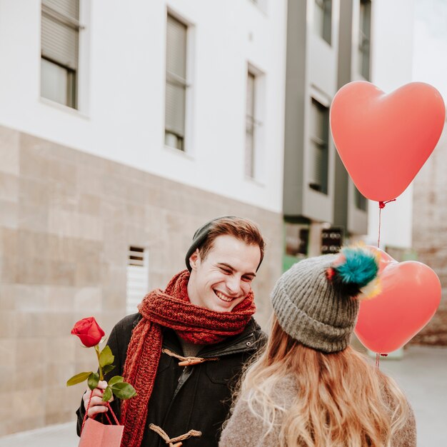 Pareja alegre con globos y regalos