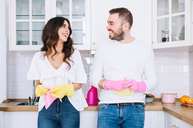 Pareja alegre en guantes con rociador