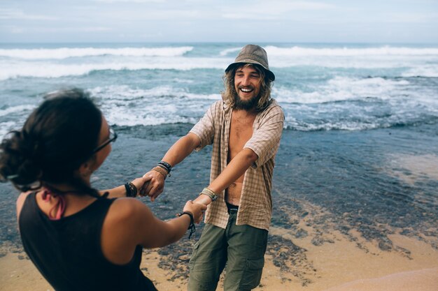 Pareja alegre jugando en la playa