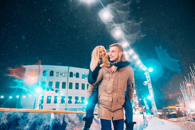 Pareja alegre y juguetona en trajes cálidos de invierno está jugando