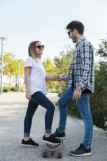 Foto gratuita pareja alegre con longboard