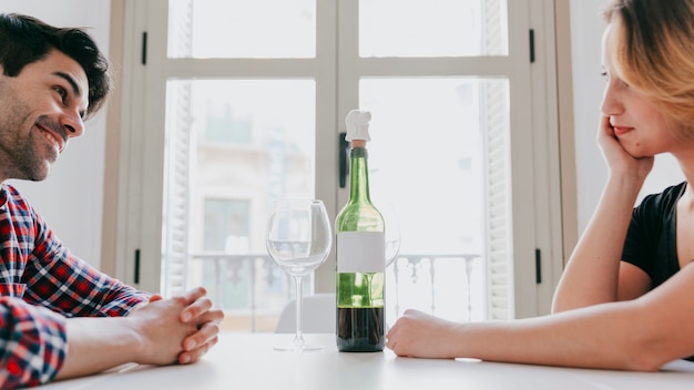 Pareja alegre en la mesa con vino