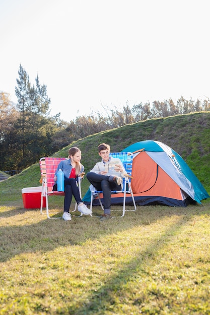 Pareja alegre mirando un mapa en el bosque