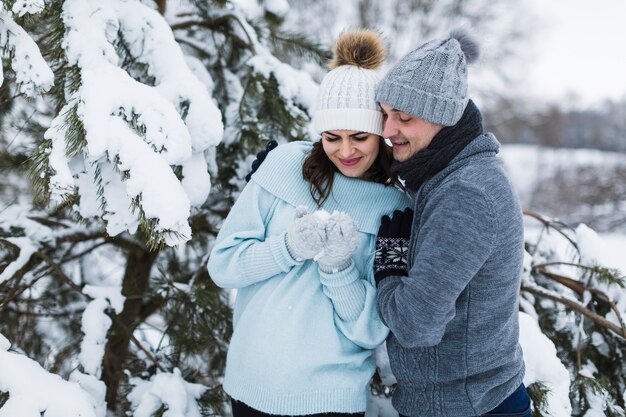 Pareja alegre mirando nieve