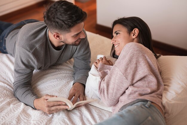 Pareja alegre relajante en la cama