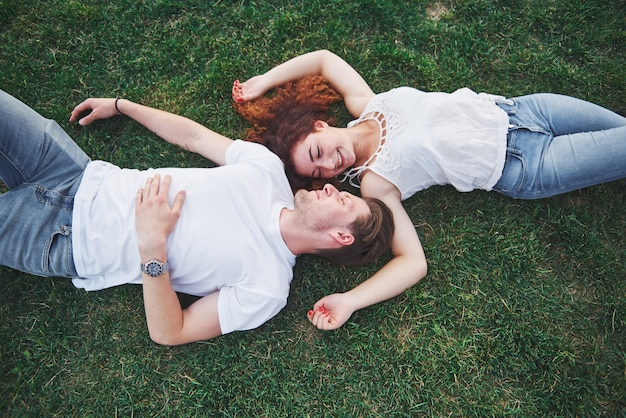 Pareja alegre tirado en el pasto.