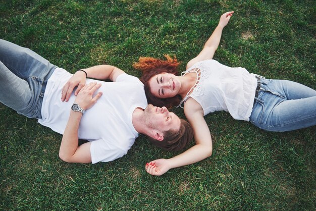 Pareja alegre tirado en el pasto.