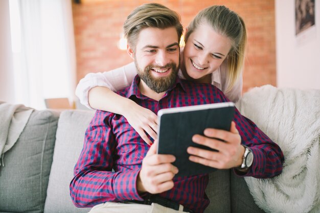 Pareja alegre usando tableta juntos