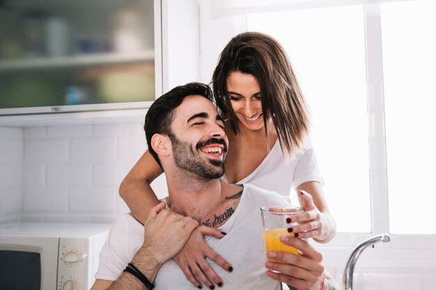 Pareja alegre con vaso de jugo