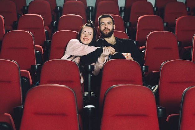 Pareja alegre viendo la película en el cine