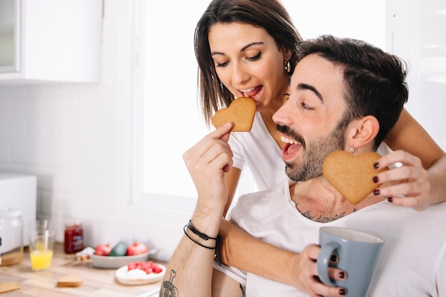 Pareja alimentándose mutuamente con galletas