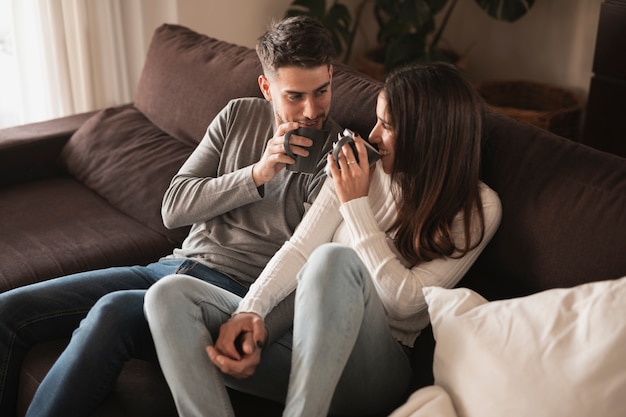 Pareja de alto ángulo en casa tomando café