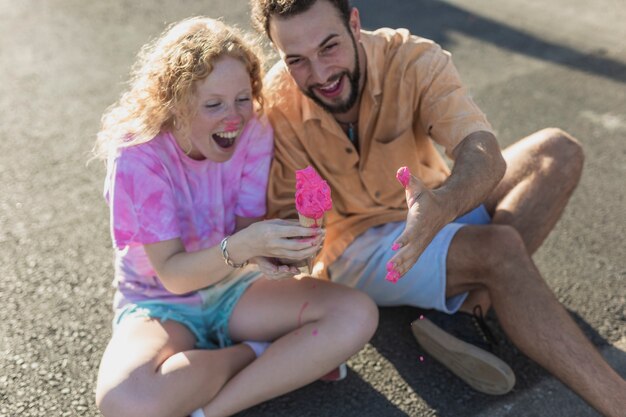 Pareja de alto ángulo divirtiéndose con helado