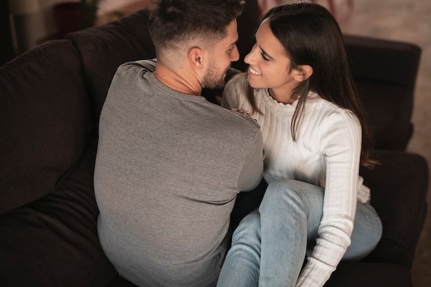 Foto gratuita pareja de alto ángulo en el sofá abrazando