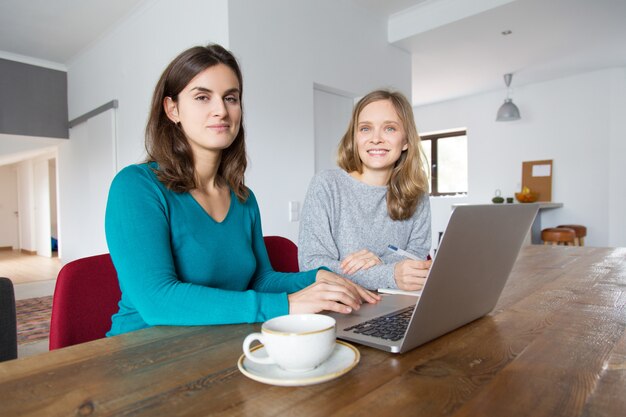 Pareja de alumnos colaborando en proyecto en casa.