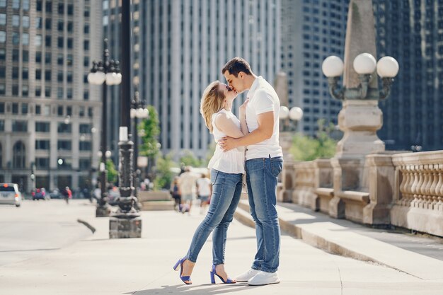Pareja de amantes jóvenes y con estilo en camisetas blancas y jeans caminando en una gran ciudad