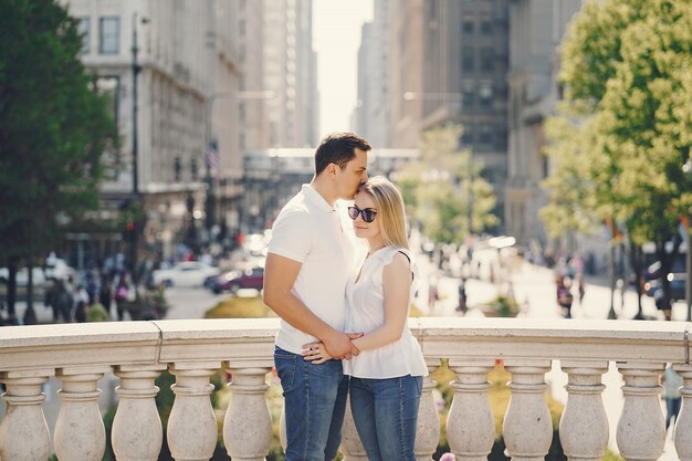 pareja de amantes jóvenes y con estilo en camisetas blancas y jeans caminando en una gran ciudad