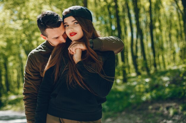 Una pareja de amor con estilo y brillante camina en el bosque soleado