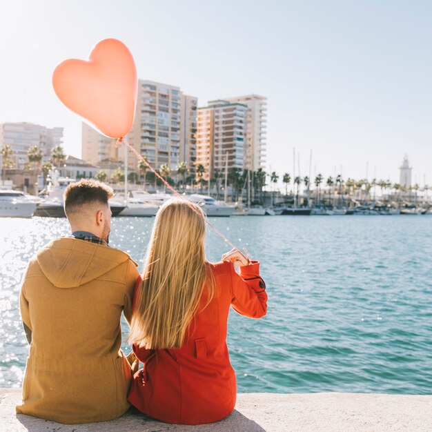 Pareja en amor con globo en paisaje urbano