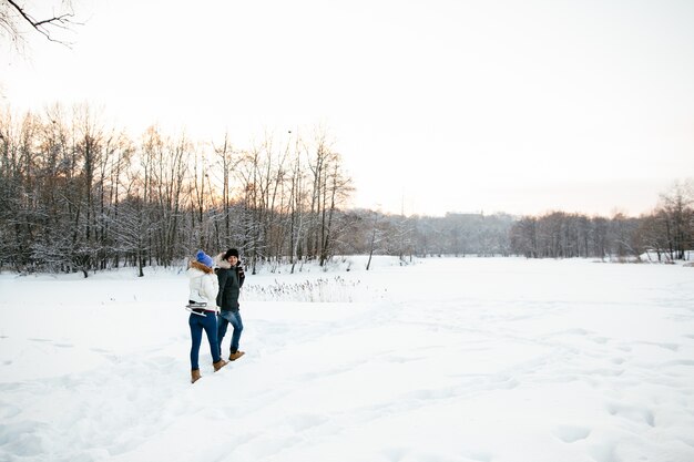 Pareja en amor con patines que van a patinar en una pista de hielo. Día de invierno cubierto de nieve.