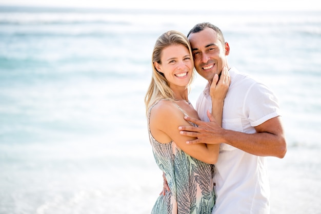 Pareja amorosa abrazando en la playa del mar de verano