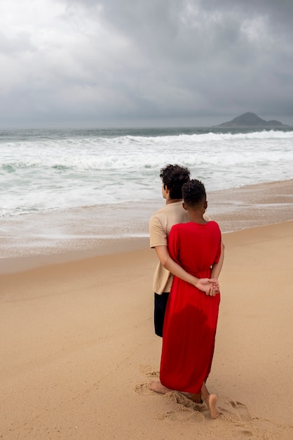 Pareja amorosa mostrando afecto en la playa cerca del océano