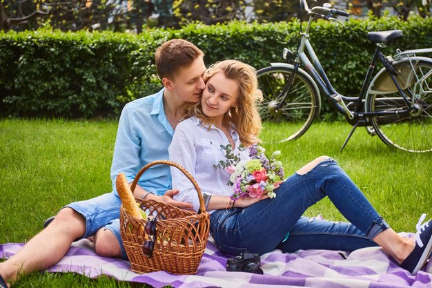 Pareja amorosa en un picnic después de un paseo en bicicleta en un parque.