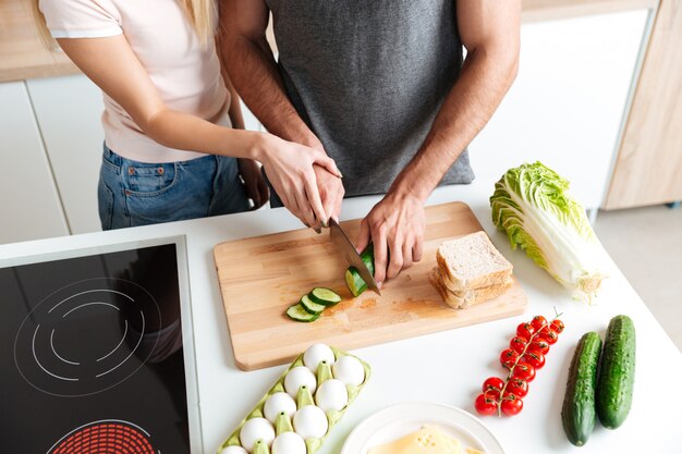 Pareja amorosa de pie en la cocina y cocinar juntos