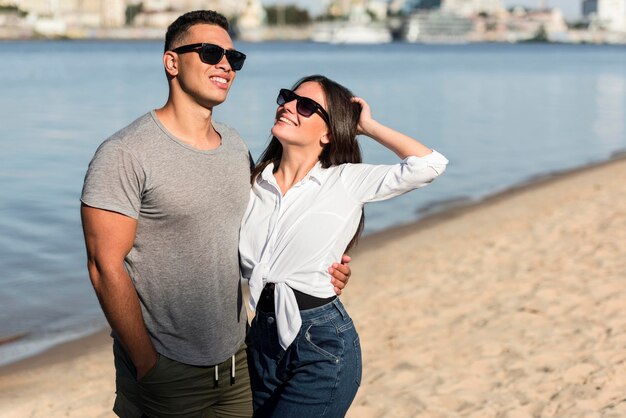 Pareja amorosa posando juntos en la playa