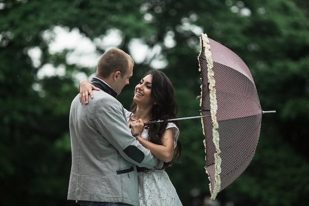 Pareja amorosa sosteniendo un paraguas