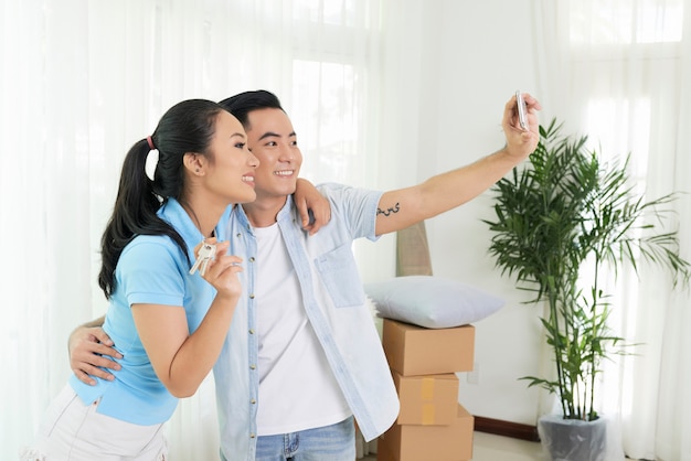 Pareja amorosa tomando selfie en casa nueva