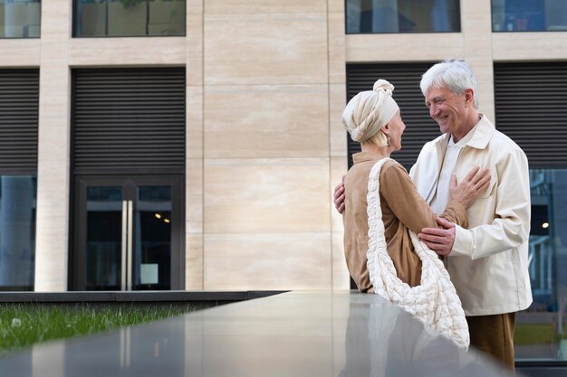 Pareja de ancianos abrazados al aire libre en la ciudad