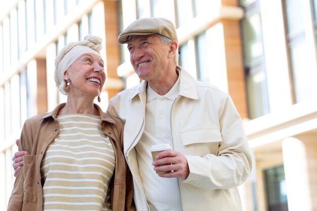 Pareja de ancianos al aire libre en la ciudad con una taza de café